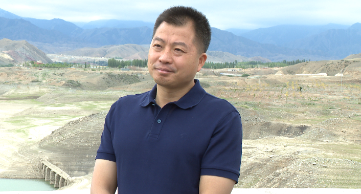 在新地乡新地村,潘素华查看冬春小麦长势和农作物受